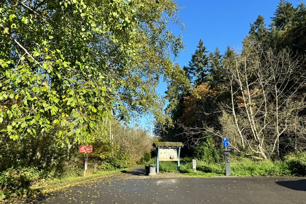 Park entrance with paved pathway leading towards the beach area.